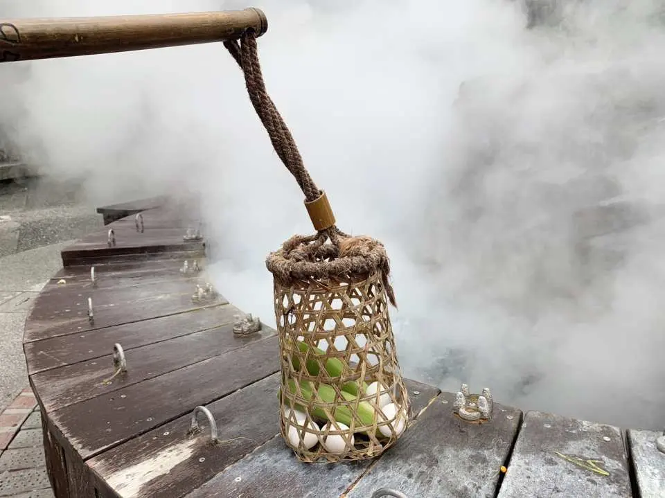 宜蘭太平山の温泉で、竹製のカゴに入った卵を熱湯に浸して調理する様子。新鮮な温泉卵を作るユニークな体験。