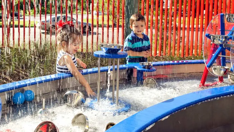 At the San Antonio Children's Museum water play area, two children happily play with water wheels and fountains, offering endless family fun with CityPASS®.