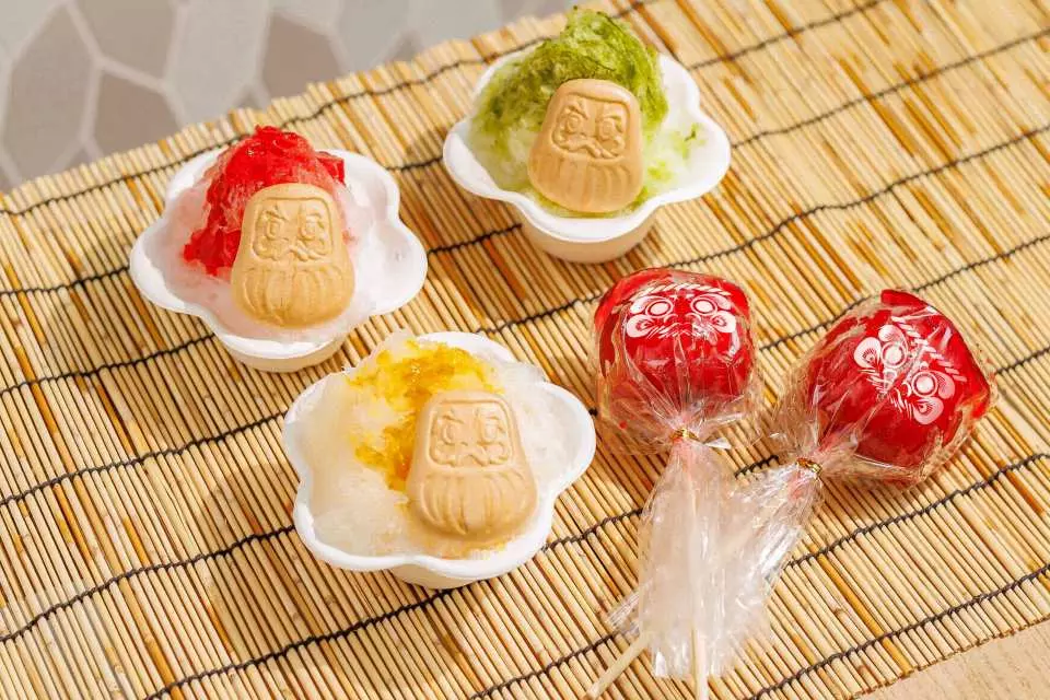飲食屋台 - SWEETS -：スイーツ屋台では、夏まつり定番のかき氷や、オリジナルのだるまパッケージに包まれたりんご飴を販売。かき氷シロップには、京都の老舗茶舗「福寿園」の抹茶を使用した抹茶味、石川県能登産ゆずを贅沢に使用したゆず味といった、日本ならではの食材を楽しめる和風かき氷をご用意しています。 ※スイーツまたはスナックから1品分は入場チケットに含まれます。2品目以降は都度、ご購入いただけます。
