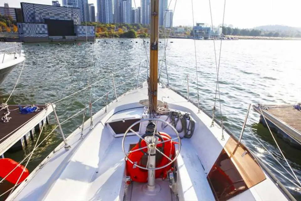 An elegant sailing yacht docked at the Han River pier, clearly showing the bow, helm, and deck, offering another unique private yacht rental experience.