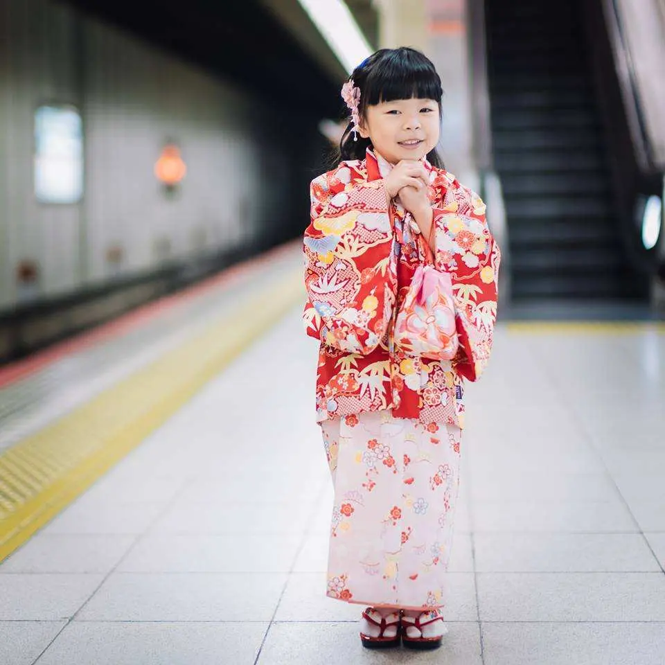 板橋優花梨和服浴衣租借，可愛小女孩穿著鮮豔浴衣，笑容滿面地在捷運站內，展現日式童趣。