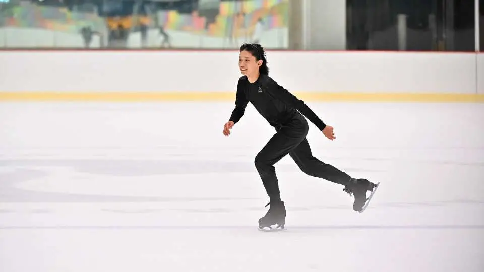 台北忠泰樂生活極光冰場上，一位身穿黑色運動服的女性優雅地單人滑冰，展現冰上樂趣與專業感。