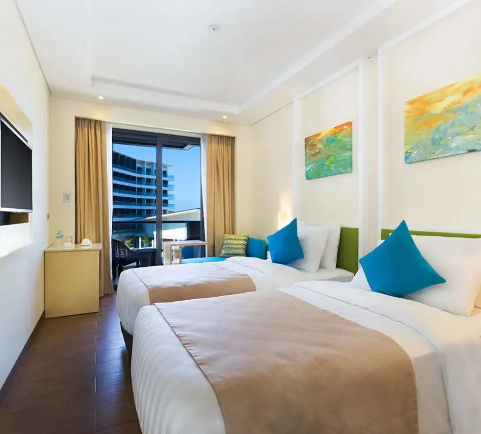 Deluxe Rooms: Bathed in natural daylight and coral-inspired hues, these 27 sqm rooms feature a private balcony with views of the pool or golf course, providing a serene and inviting atmosphere.