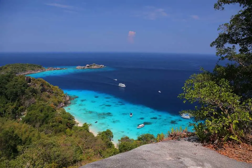 从斯米兰群岛标志性帆船岩俯瞰令人惊叹的全景，湛蓝与碧绿海水交织成热带海湾，岛屿葱郁，展现壮丽自然美景。