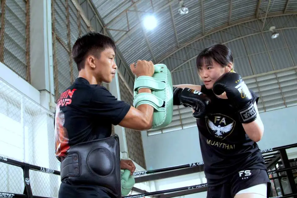 ในคลาสมวยไทยสำหรับผู้เริ่มต้นที่กรุงเทพฯ ครูฝึกมืออาชีพสอนนักเรียนหญิงฝึกชกมวยในสภาพแวดล้อมที่ปลอดภัยและสนับสนุน ให้คุณเริ่มต้นได้อย่างง่ายดาย