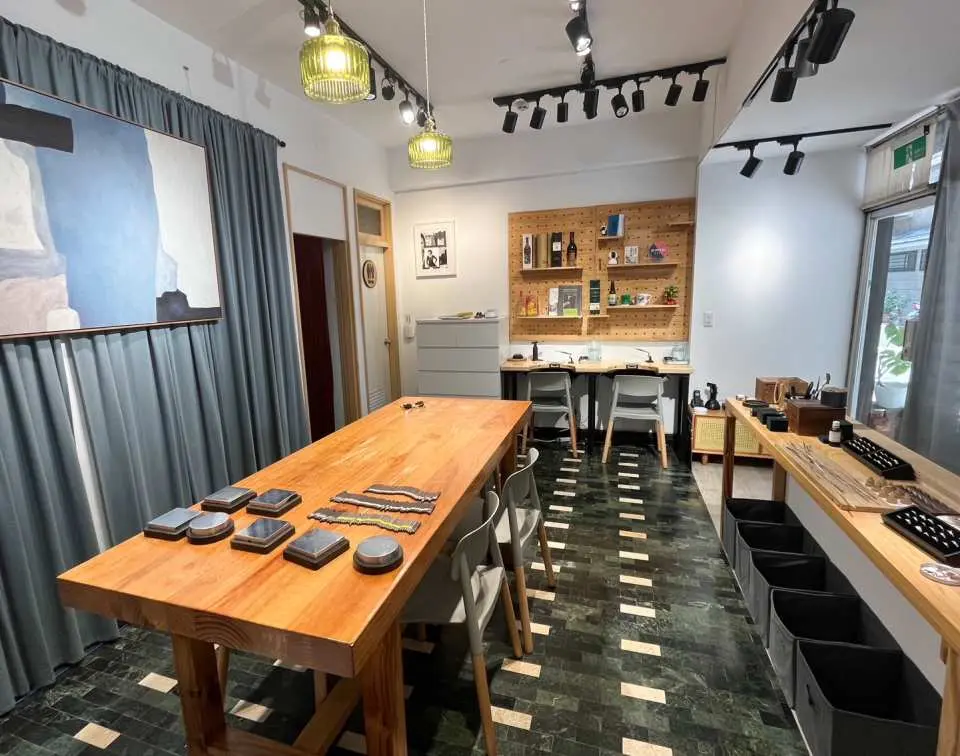 台北VIC WANG金工私塾工作室全景，長型木桌上擺滿金工材料與工具，準備迎接學員進行專業指導下的手作戒指課程。