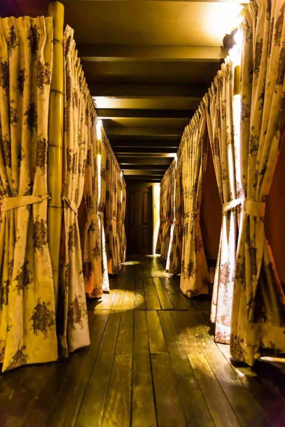 Hành lang yên bình và được chiếu sáng với rèm che dẫn đến các phòng massage riêng tại Alam Beauty & Wellness Spa Kuala Lumpur, mang lại trải nghiệm tĩnh lặng.