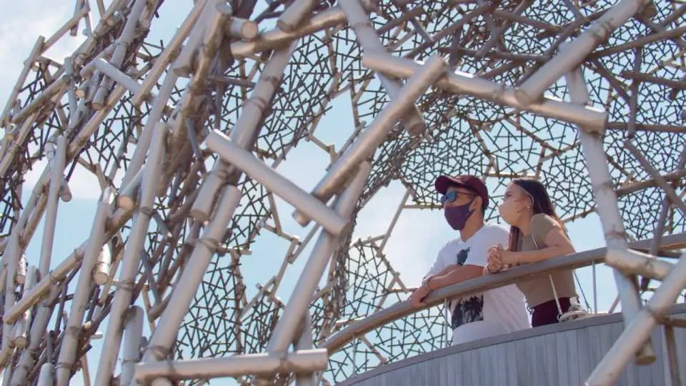 Two visitors at Kobe's Mount Rokko 'Nature Feel Observation Deck' admiring the unique metallic mesh structure, experiencing the fusion of nature and art, and exploring a distinctive Kansai tourist attraction.