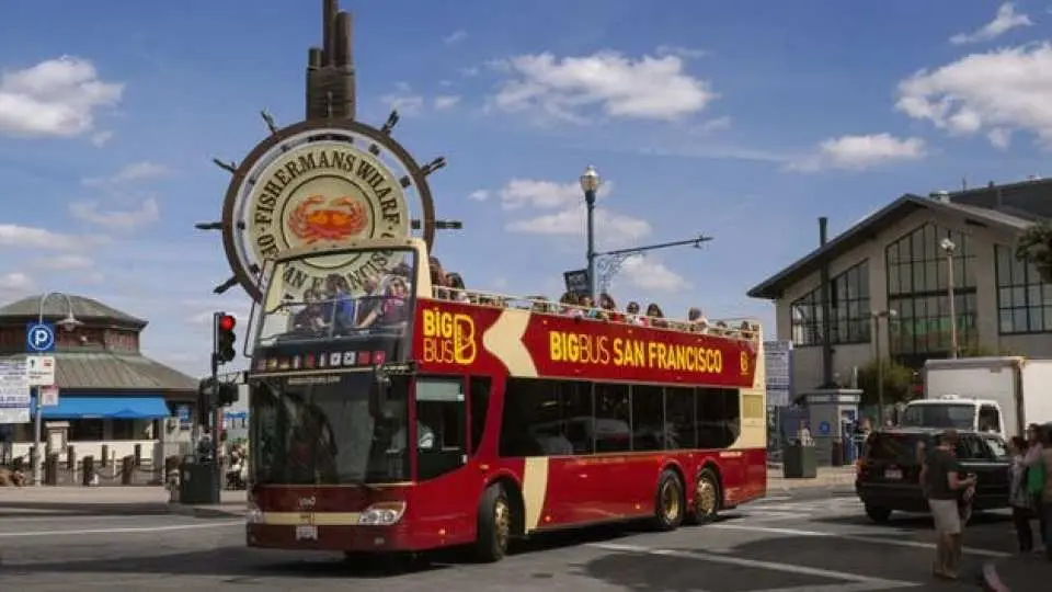 A red double-decker Big Bus San Francisco hop-on hop-off tour bus with passengers near Fisherman's Wharf, offering convenient city sightseeing.