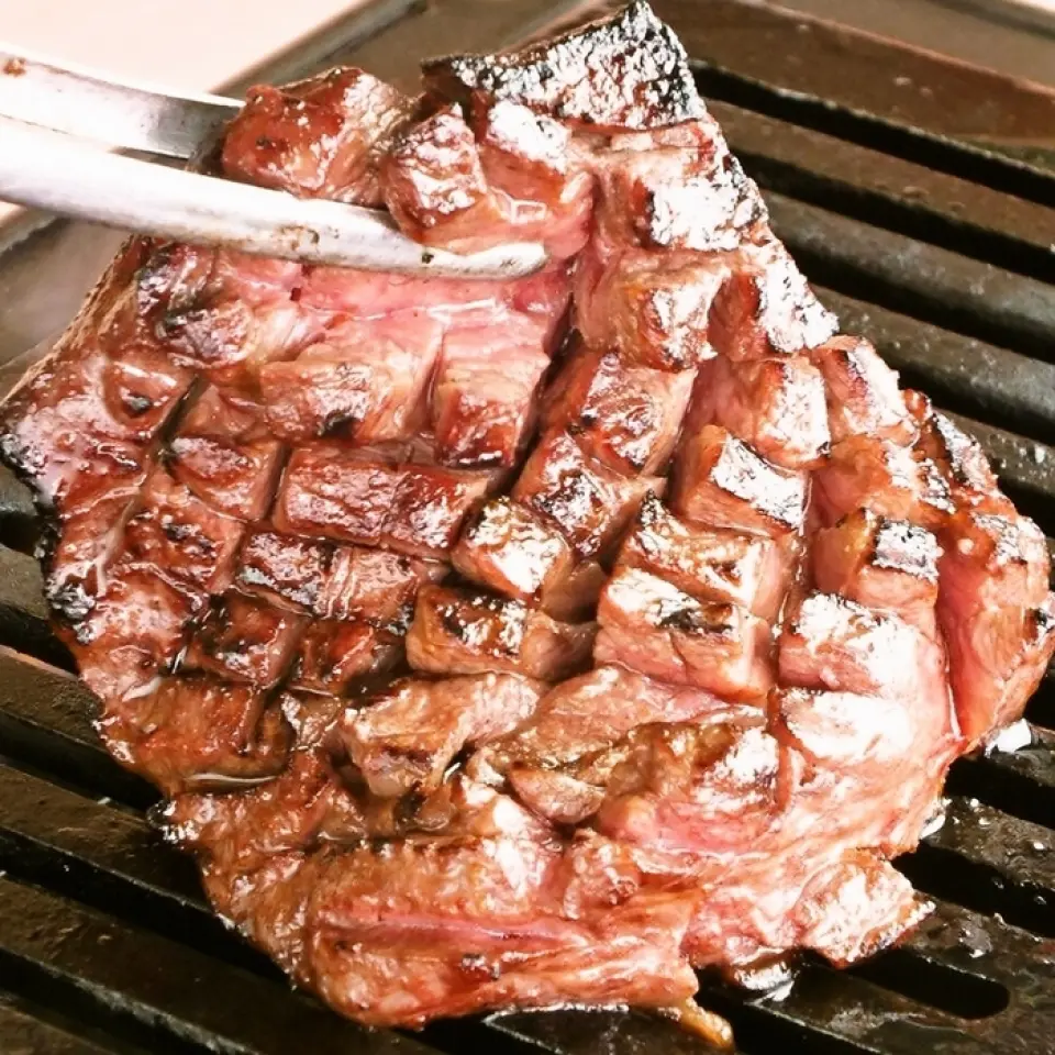 The thickest part of the skirt steak is cut into a lattice pattern while still in its original shape. After grilling on both sides, cut it with scissors and enjoy.