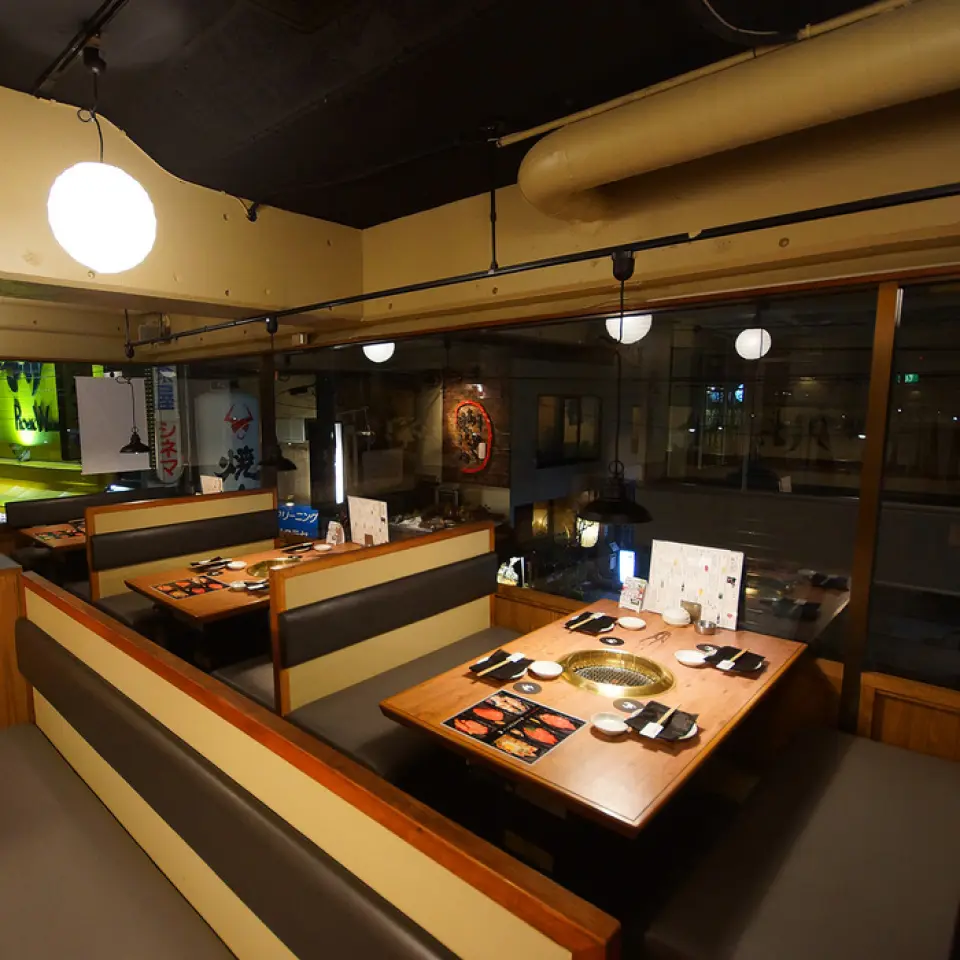 店内装潢以黑色和木纹为主，营造出沉稳的氛围。我们试图创造一个让您在任何情况下都可以舒适地度过时光的空间，而不是高端烤肉店的高端氛围或大众市场烤肉店的拥挤氛围。座位最多可容纳 6 人的箱形靠窗座位很受欢迎，您可以一边享受烤肉，一边欣赏窗外的风景。宽敞的店内设有大大小小的座位，包括半包间和包厢座位。它可用于多种场合，从小型团体到大型私人宴会。