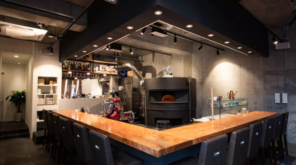 The counter and tables are made from wood cut from a single large tree, warming and adding a powerful touch to the minimalist, inorganic space. Our restaurant, tucked away underground in a back alley, is a hidden gem known only to those in the know. It is conveniently located just a three-minute walk from Shirokanedai Station, so it is perfect for a variety of occasions, such as after work with colleagues or a partner, or for family meals or anniversaries. Enjoy pizza and wine in a high-quality space filled with the rich aroma of wheat.