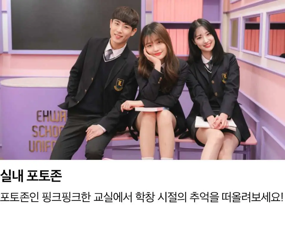 한국 서울 이화교복점의 교실 포토존에서 세 친구가 한국 교복을 입고 즐겁게 책상 의자에 앉아 학창 시절을 추억하고 있습니다.