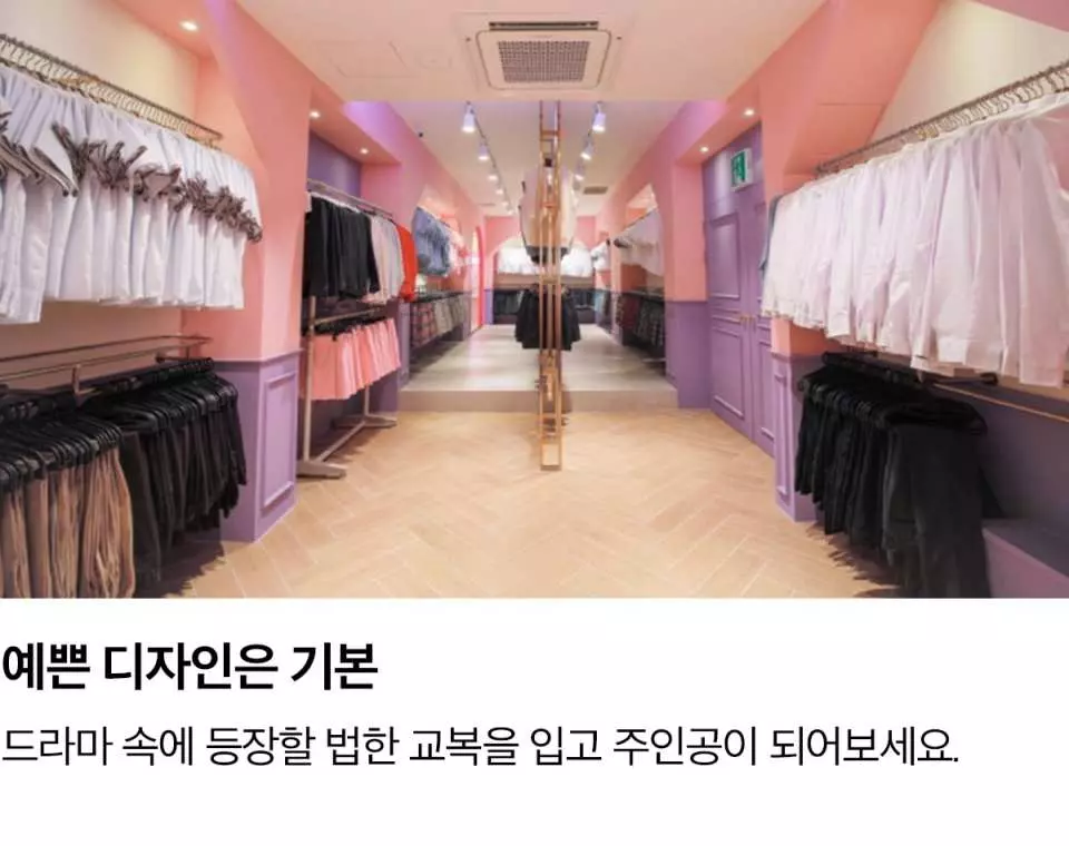 한국 서울 이화교복 대여점 내부는 넓고 밝은 복도로, 양쪽에 다양한 한국 교복 스타일이 걸려 있어 고객들이 편리하게 선택할 수 있습니다.