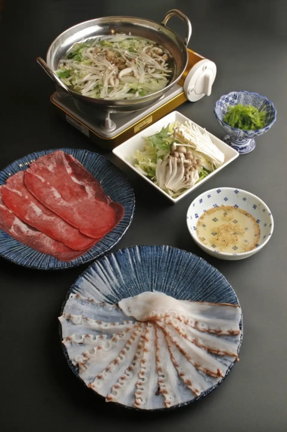 我們的特色菜是涮鍋。與普通的涮鍋不同，這份菜單可以讓您享受海洋和陸地的美味。首先是海鮮。請享用使用北海道鹿部產的活章魚製作的涮鍋。肉被切成又長又薄的片，迅速浸入盛滿蔬菜的鍋子裡。吃完章魚後，再來嚐嚐牛舌。牛舌從舌到舌切成薄片，可以加入黑胡椒改變風味。我們也建議嘗試搭配我們秘製的自製鹹橙醋醬。