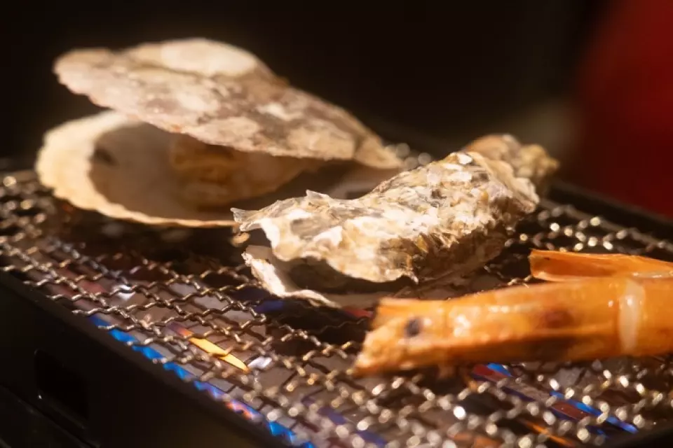 在海灘上烤製的新鮮海鮮，淋上醬油、柑橘醬和奶油，真是一道精緻的菜餚！牡蠣、白蛤、扇貝、蠑螈、蝦350日圓起！吃文字燒之前請先試試看！