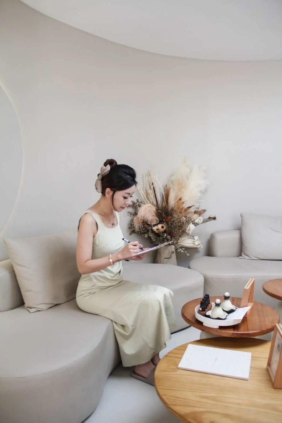 Khách hàng tại Hama Hair SPA Đài Bắc đang điền phiếu yêu thích cá nhân trong khu vực chờ trang nhã, thoải mái, đảm bảo chuyên viên trị liệu cung cấp trải nghiệm gội đầu kiểu Việt và SPA tùy chỉnh.