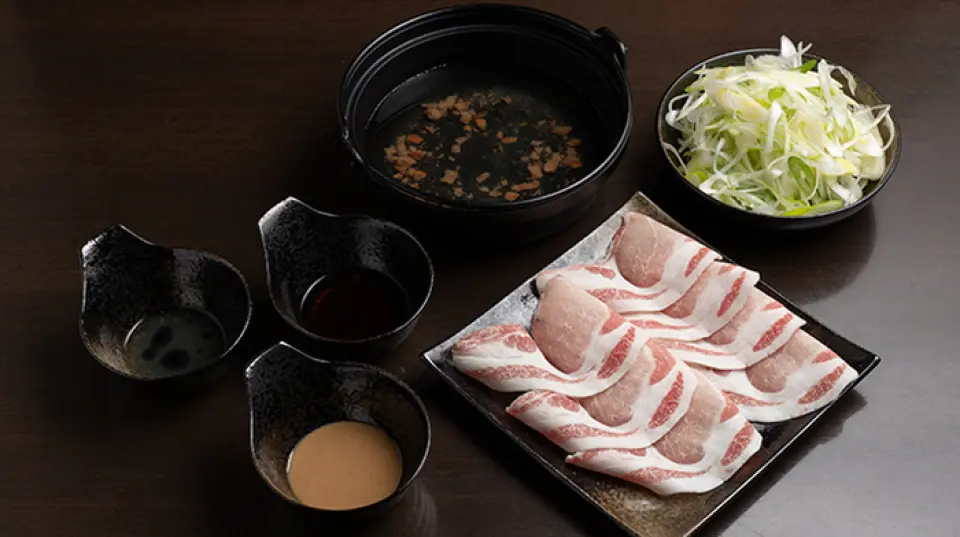 เนื้อหมูที่เราใช้สำหรับชาบู-ชาบูอันเป็นเอกลักษณ์ของเราคือ "หมูอากู" ที่หายากจากโอกินาวา ซึ่งมีรสชาติระดับสูงสุดและผลิตหมูได้เพียง 300 ถึง 400 ตัวในแต่ละปี และเราใช้มันเพื่อสร้างความสมดุลของรสชาติที่สมบูรณ์แบบ ความเข้มข้น เนื้อสัมผัส และความกรอบ คัดสรร "หมูบิเมะ" จากจังหวัดอิบารากิอย่างพิถีพิถัน เราจะจัดเตรียมวิธีการปรุงอาหารที่ดึงเอาสิ่งที่ดีที่สุดของทั้งสองอย่างออกมาให้กับคุณ หั่นเป็นชิ้นบางๆ เพื่อให้ความร้อนกระจายทั่วถึงโดยใช้ประโยชน์จากเส้นใยที่มีคุณภาพ เมื่อผ่านน้ำซุปจะมีกลิ่นหอมอ่อนๆ และดึงรสชาติออกมาในขณะที่ยังคงความนุ่มของเนื้ออยู่