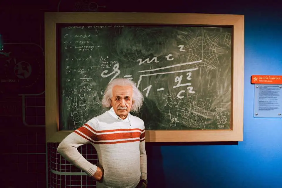 The Albert Einstein wax figure at Madame Tussauds Bangkok, standing thoughtfully in front of a blackboard filled with complex scientific equations, inviting visitors into the world of physics.