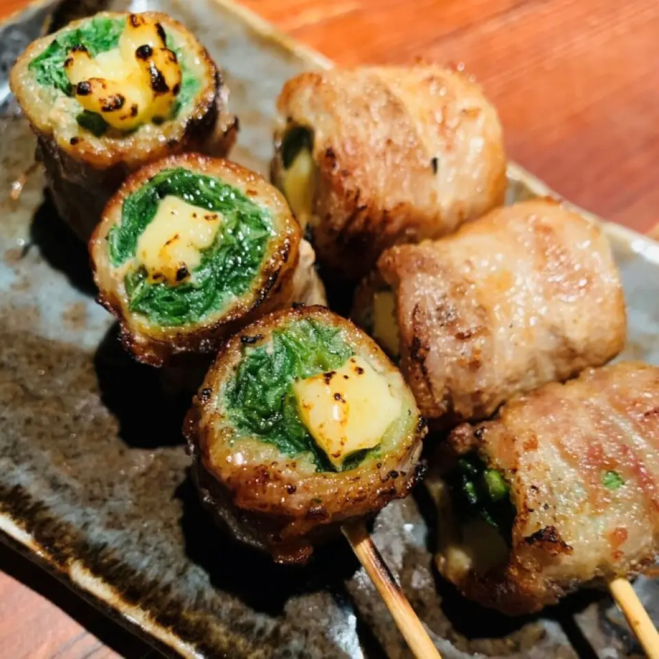 用五花肉和培根包裹時令蔬菜的「蔬菜捲串」是我們的人氣招牌菜。為了讓顧客能夠輕鬆安全地享用每一串，我們都小心翼翼地串起來。從標準的烤串到不常見的烤串，例如深受女性歡迎的經典生菜捲和酪梨捲，我們總有大約 20 種可供選擇。每串的調味料都不同，請大家比較一下♪