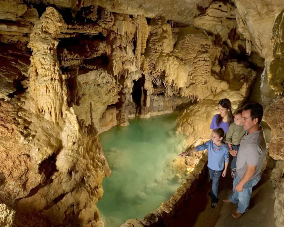 A family exploring Natural Bridge Caverns in San Antonio, admiring the underground lake and spectacular stalactite and stalagmite formations, enjoying a natural wonder.
