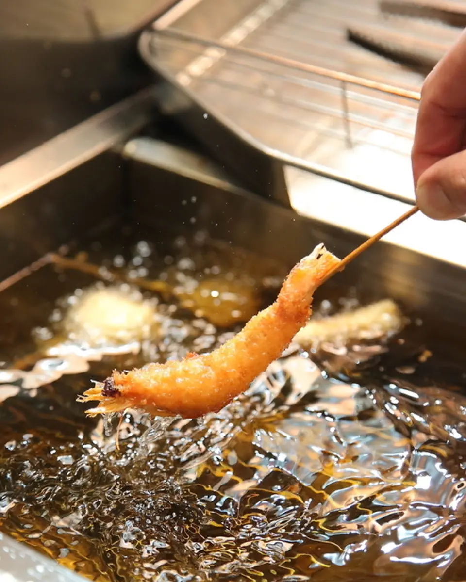 來大阪一定要嚐嚐「炸串」！我們使用每天從市場購買的新鮮食材。該油主要由荷蘭純正豬油調和而成，可用於肉類、魚類和蔬菜。我們對炸串鬆軟口感的關鍵「練谷」的配方非常講究，而賦予炸串酥脆口感的麵包屑則每天磨碎。醬汁是由富含膠原蛋白的自製雞湯和原味醬汁混合而成。請嘗試一下♪