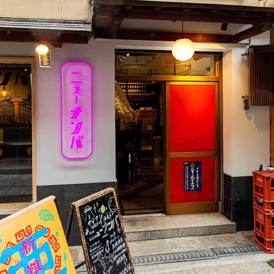 我们店位于俗称“米其林街”的地方！沿着街道继续往前走，右手边就会看到一块闪闪发光的粉红色霓虹灯招牌。这是一家在霓虹灯照耀下神秘而古雅的商店。室内设计类似于亚洲街头小吃摊，非常适合独自喝一杯放松，或举办宴会和其他聚会。我们期待您的光临。