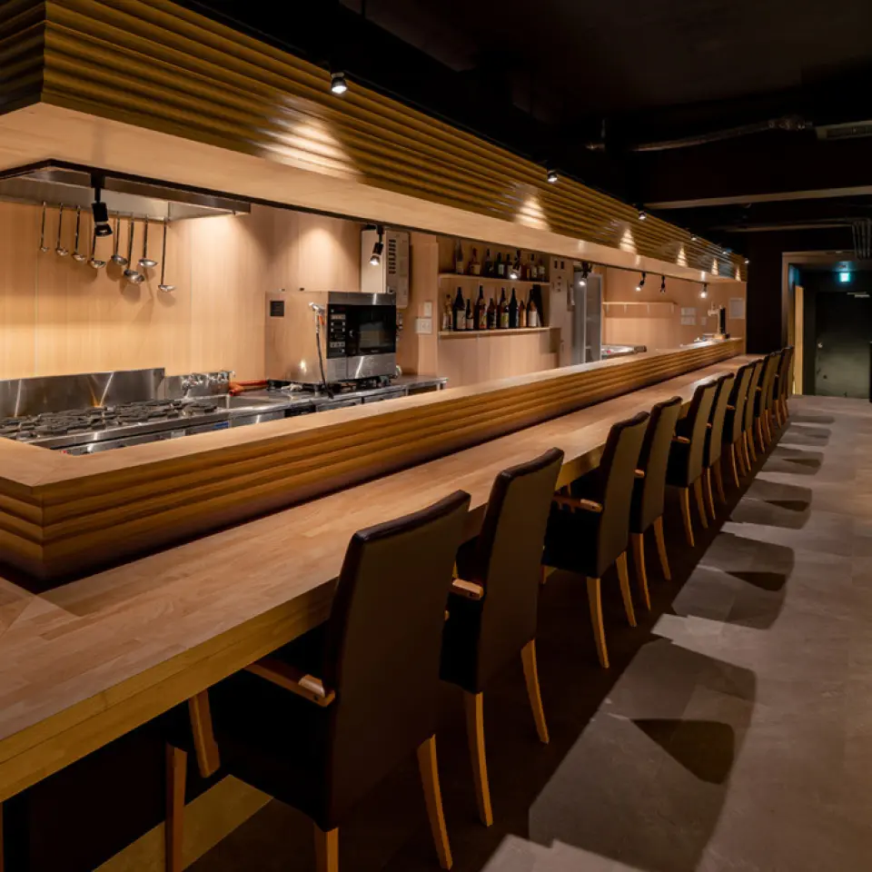 The interior of the restaurant is a relaxing space with a warm wooden feel. The traditional Kyoto color of wisteria is used as an accent, creating a modern and stylish atmosphere. There are counter seats for those dining alone, as well as semi-private rooms for more privacy. The counter is an open kitchen, where you can watch the skilled chefs at work. If you're lucky, you might even see a yellowtail being dynamically butchered. This restaurant is perfect for a wide range of occasions, from everyday use to entertaining and dates.