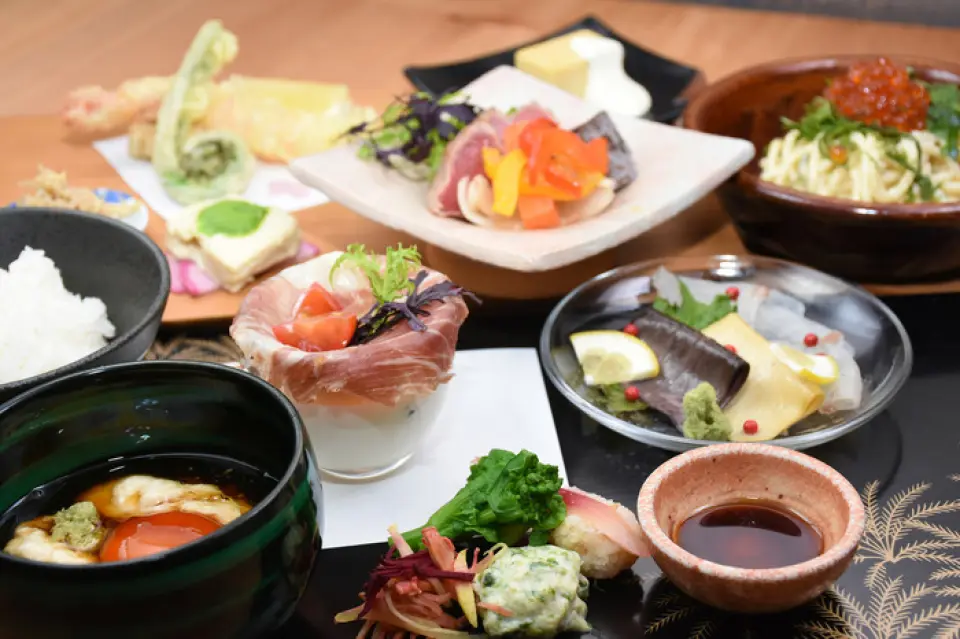 我們提供以日本料理為基礎的創意腐皮料理。我們有兩道主菜：魚和肉。如果您的主菜是魚，我們就上一小碗肉，如果您主菜是肉，我們就上一小碗海鮮，這樣您就可以兩樣都享用了。因為我們使用當季食材，所以內容每兩個月更換一次。請盡情享受從開胃菜到甜點的豆腐皮相關菜單。晚上8點以後，我們有酒吧時間，我們還提供小吃、特色菜、米飯等單點菜色。