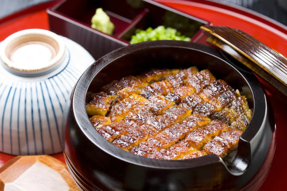 本店引以为傲的菜肴“鳗鱼饭”采用精心挑选的鳗鱼原料制作而成。我们从根据季节采购的精选食材中，严格挑选出最适合鳗鱼饭的食材。这意味着您可以享受完美的脂肪量、浓郁的肉味以及烤皮的香味。请品尝我们精心挑选的大米与绝妙的风味和谐。这是运用材料、技术和热情精心打造的杰作。我们还提供外卖菜单。