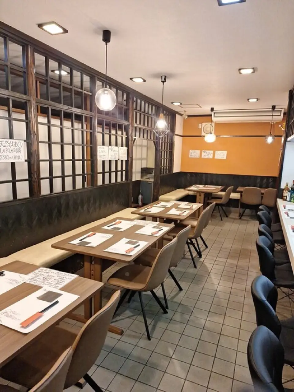 【居酒屋Emi】位于一栋古色古香的老建筑的一楼。店内是充满怀旧气息的日式空间。 18张榻榻米的大厅内设有可以观看烹饪的吧台席、带长凳的宽敞桌席、儿童榻榻米席。在吧台席上可以与主人聊天，享受轻松的时光。在榻榻米房间里吃饭。无论您是独自一人还是一大群人，都可以享受轻松的时光。