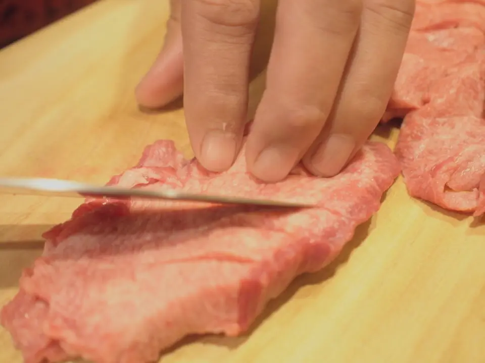 牛舌並不都是一樣的。由於每塊肉的肌腱和脂肪含量都不同，因此對於熟練的工匠來說，「判斷」它們非常重要。在本店，廚師鈴木仁會針對每一塊牛舌選擇最佳的切割方法，將其切成厚片。儘管它很厚，但卻很柔軟，而且很容易切，因為每一片都經過精心劃分。這既增加了口感和嚼勁，又進一步提升了風味，最終成就了金氏牛舌獨一無二的美味。
