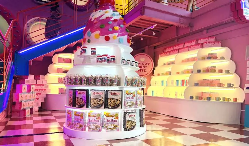 Close-up of 'Maldong Donut' cafe's unique giant cupcake display stand, filled with exquisite desserts and distinctive gifts, inviting customers to explore.