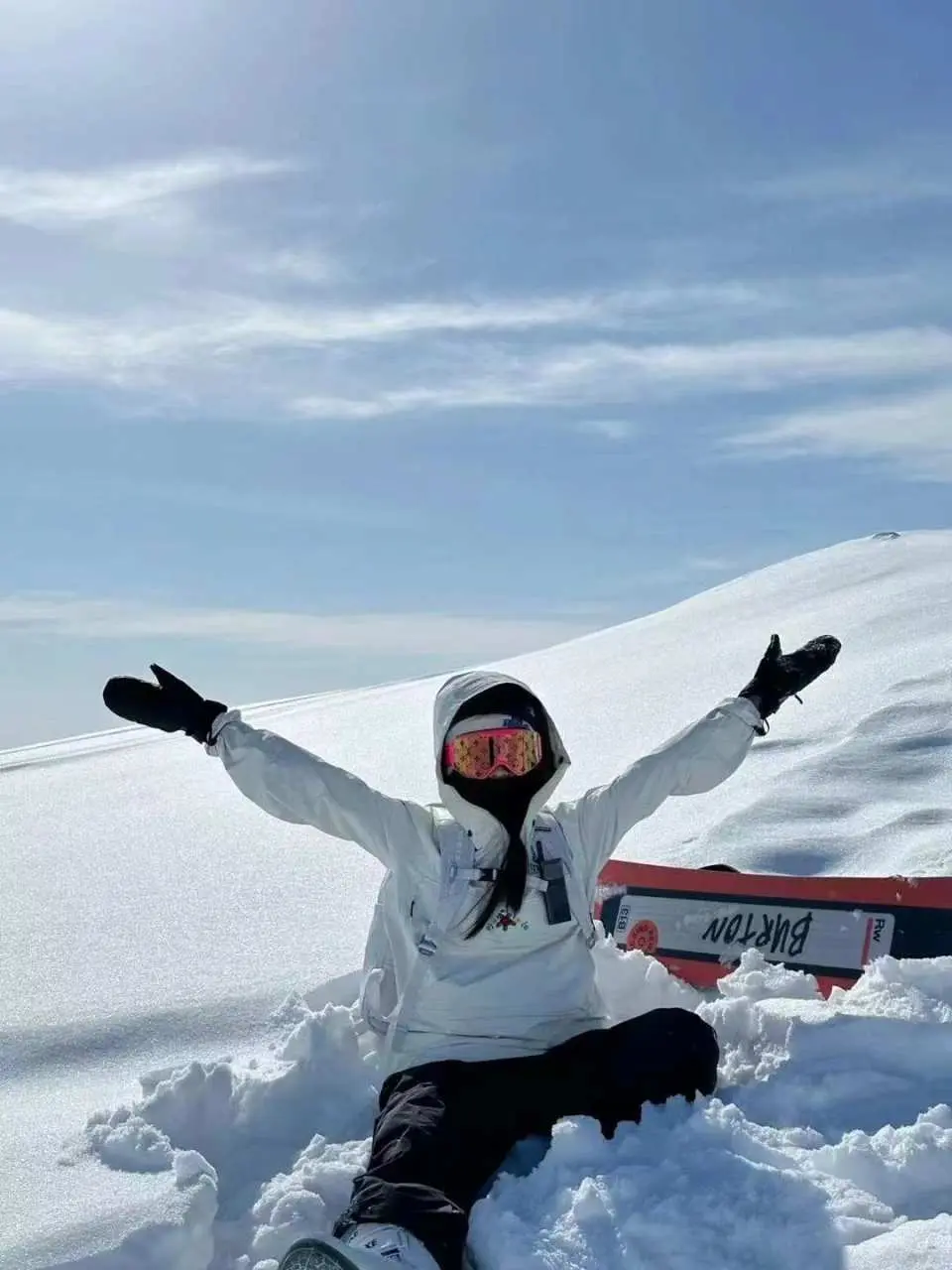 一位滑雪者在六甲山滑雪場的雪地上開心地坐著，雙手張開，享受冬季滑雪的純粹樂趣與美好時光。