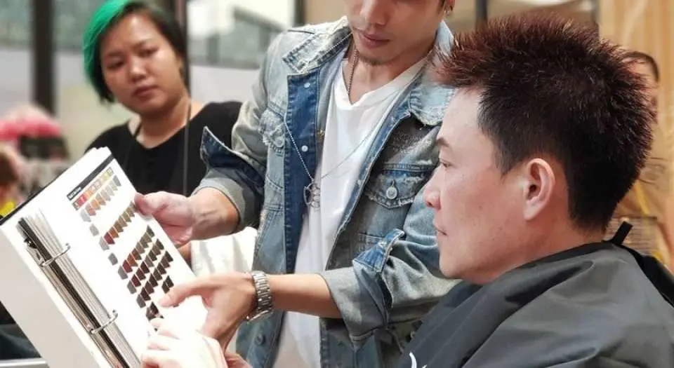 786 Salon專業美髮師在曼谷沙龍內向顧客展示髮色樣本，提供詳細染髮諮詢，確保選擇最適合的個人化髮色。