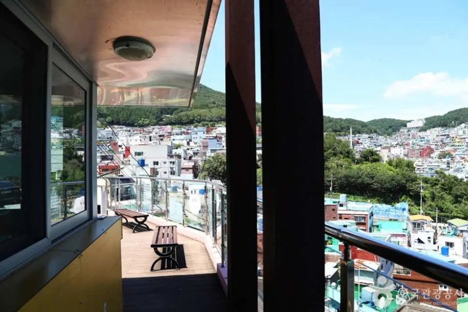 從虎川村山福洗衣店觀景台俯瞰釜山繽紛的山城村落全景，獨特的房屋群與綠意山景交織，為您帶來沉浸式治癒與歷史回憶的模擬之旅體驗。