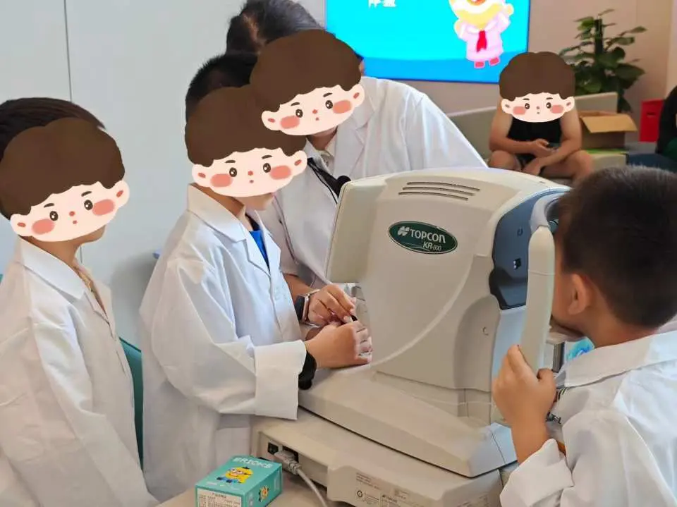 Trải nghiệm nghề nghiệp cho trẻ em ở Thâm Quyến, các bác sĩ mắt nhỏ mặc áo blouse trắng, dưới sự hướng dẫn của chuyên gia, sử dụng thiết bị nhãn khoa để trải nghiệm quá trình kiểm tra thị lực.