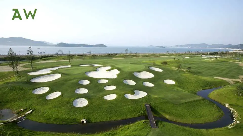 韓國濱海高爾夫球場的空拍圖，綠意盎然的球道與多處沙坑環繞海景，享受釜山、江原道的獨特高爾夫挑戰。