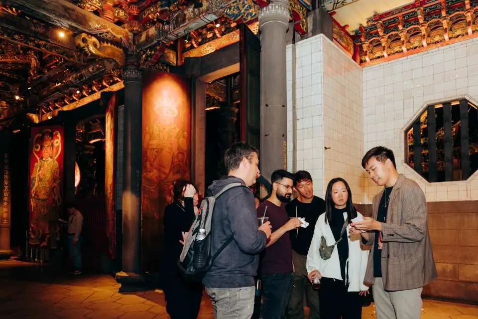 An English guide explains the intricate architectural details and historical tales inside Longshan Temple, exploring Wanhua's heritage.