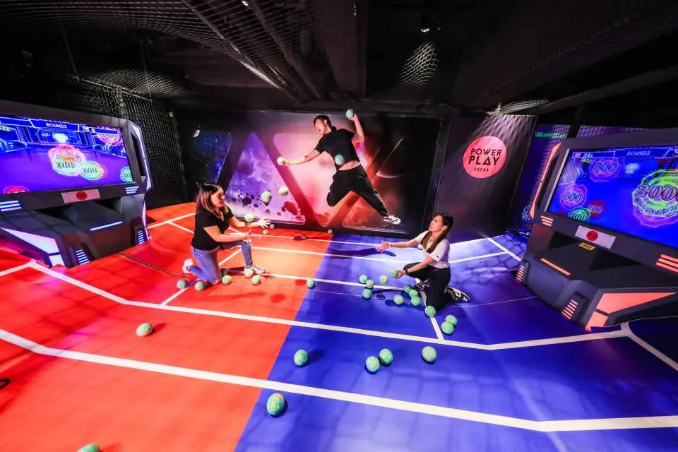 荔枝角PowerPlay Arena團體競技遊戲區Zone B，三位玩家在「Battle Ball」閃避球遊戲中，於紅白相間的地面上奮力投擲軟球。
