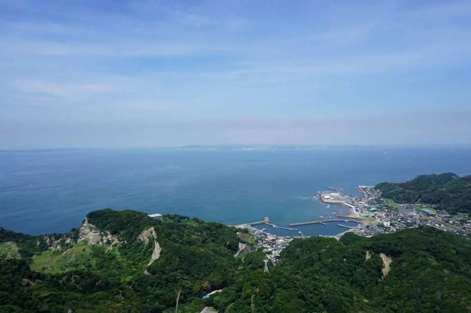 從鋸山山頂俯瞰千葉縣南房總國定公園的壯麗全景，翠綠山脈延伸至湛藍東京灣與繁忙港口。