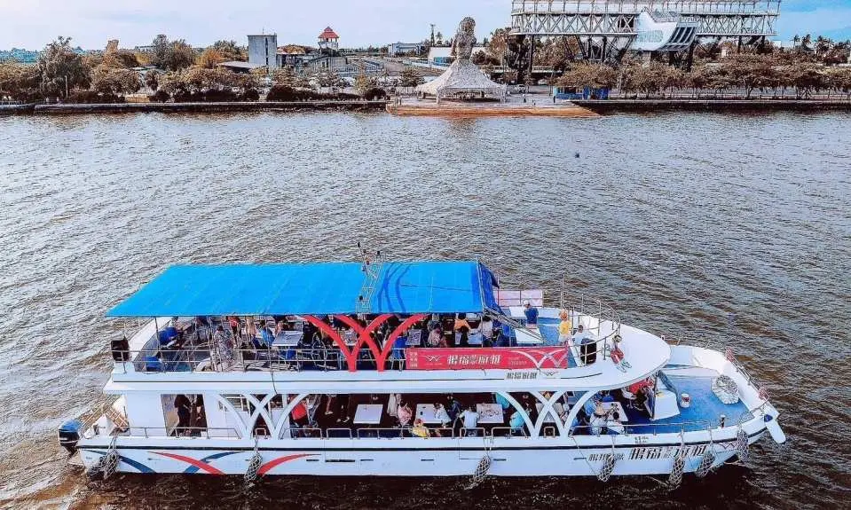 A Dapeng Bay tourist cruise ship full of visitors glides through the sunny sea, enjoying the vibrant atmosphere and natural beauty of Pingtung's Dapeng Bay, beginning a delightful journey.