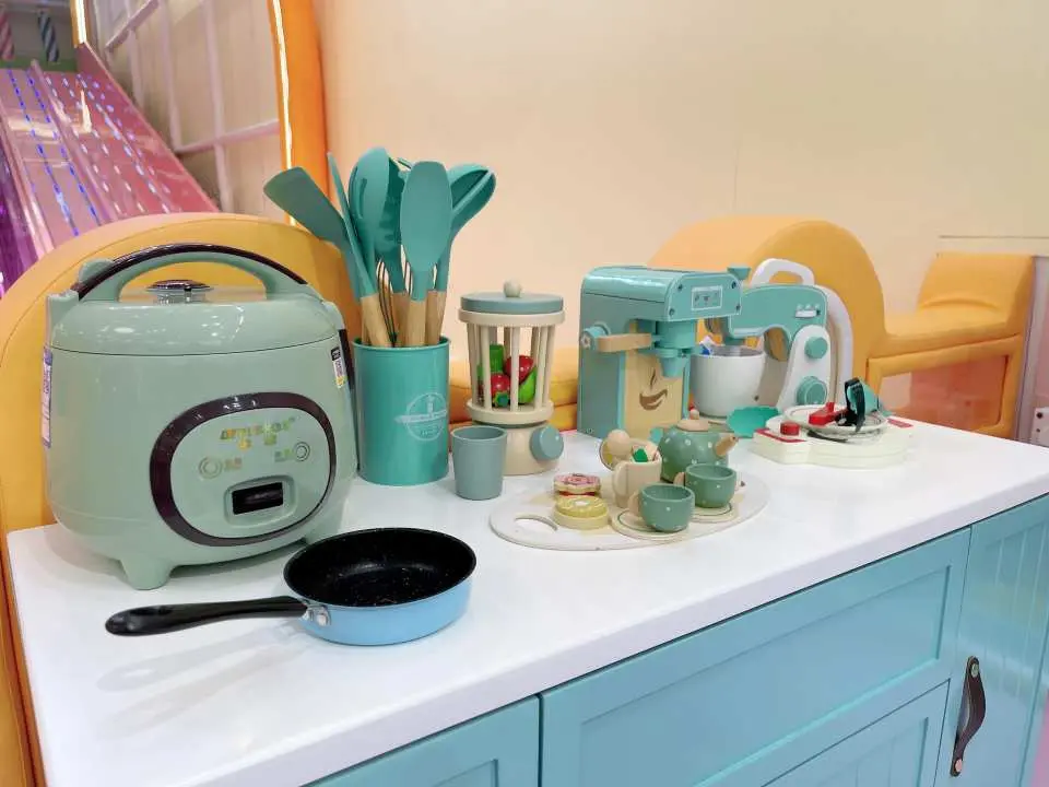 Dreamy kitchen toy area at Sunday Island Playhouse, featuring exquisite simulated appliances and tableware, allowing children to enjoy cooking and household role-play.