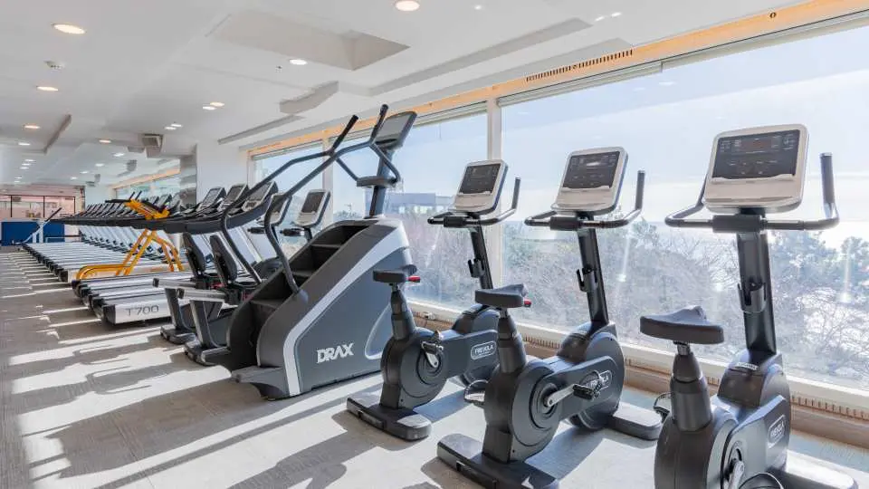 Busan Haeundae HILL SPA's well-equipped gym, featuring various exercise machines facing the windows, allowing guests to enjoy the magnificent Busan Haeundae sea view while working out.