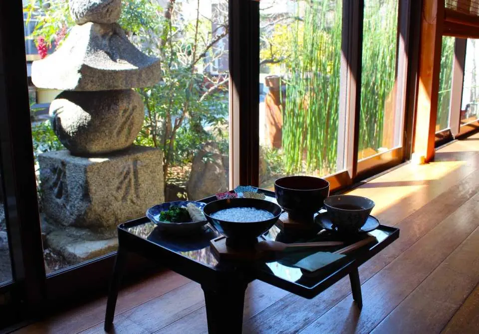 ヨガ後、大阪府堺市の妙法寺で窓辺から日本庭園を眺めながら朝粥と茶菓を楽しむ。心身を滋養するひととき。