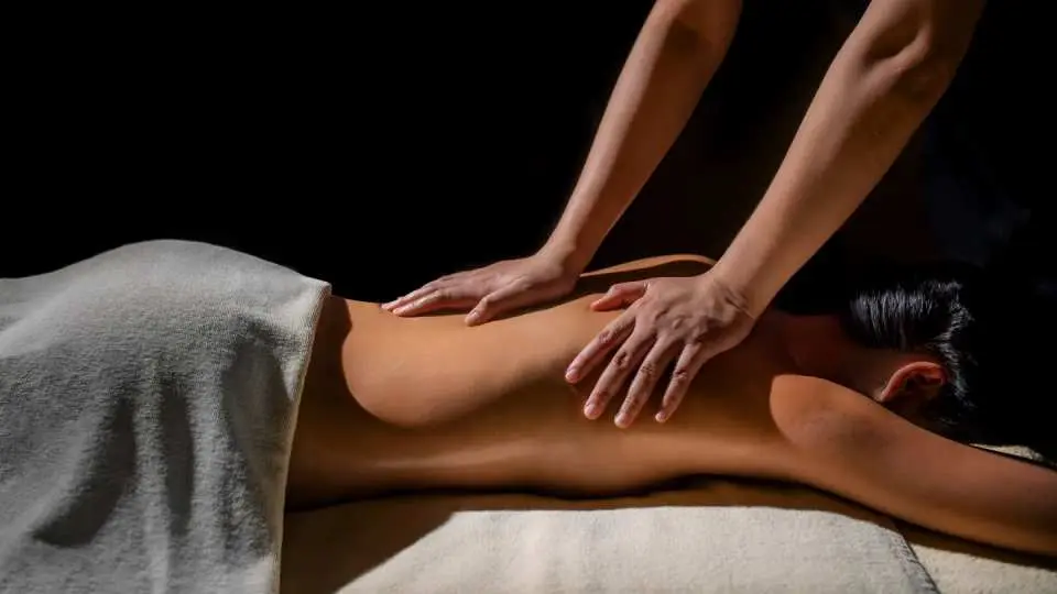 A professional therapist performing a gentle back massage during a spa experience at The Sukhothai Bangkok, offering ultimate relaxation and soothing relief.