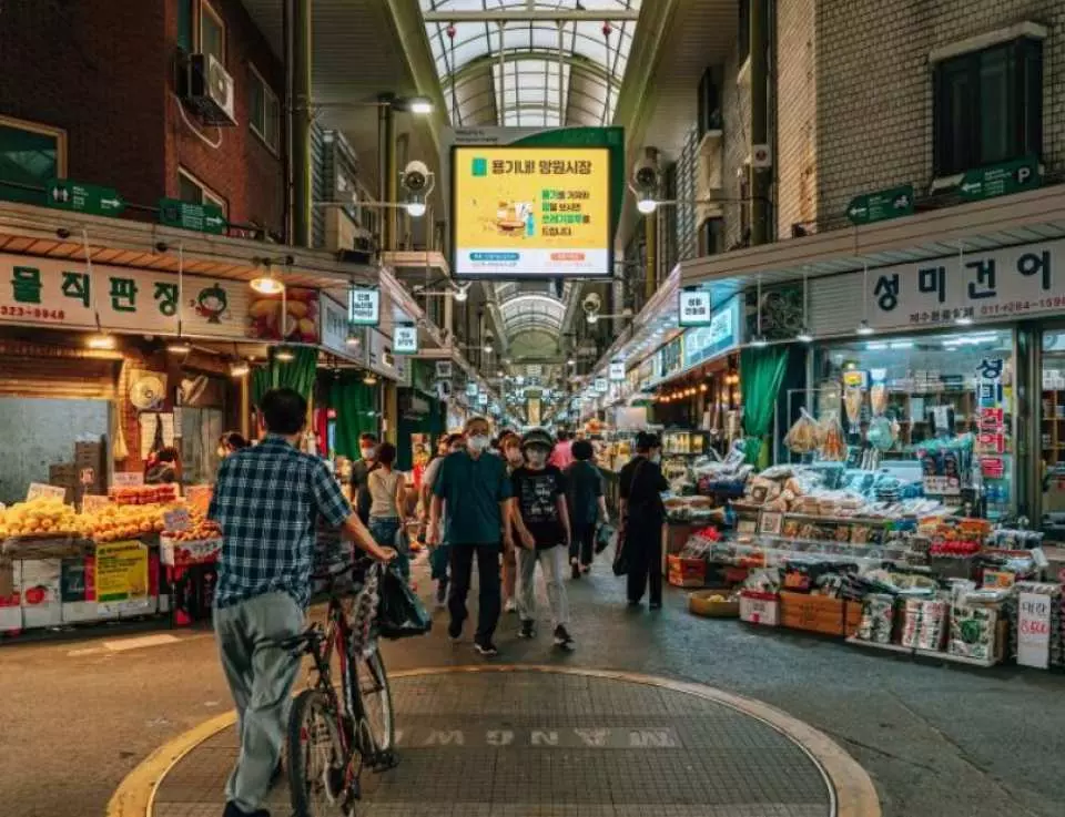 首尔望远市场热闹的传统集市景象，摊位商品琳琅满目，当地民众与游客穿梭其中，体验地道生活。探索首尔隐藏魅力。