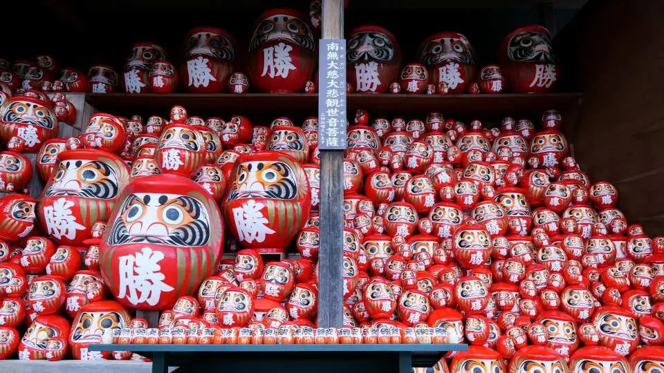 勝尾寺の堂内に積み上げられた無数の赤い勝達磨。大小さまざまなだるまは、勝利と幸運を祈願する日本の伝統的な縁起物です。