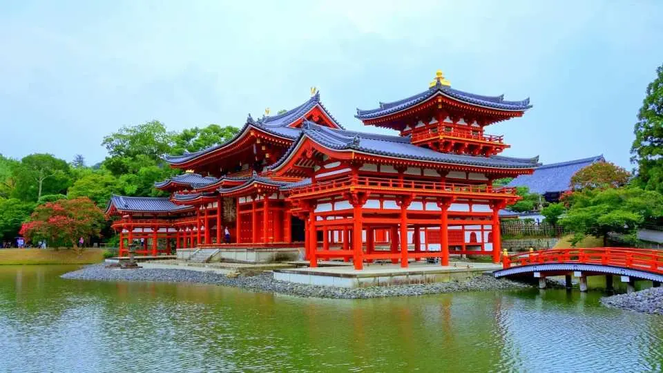 宇治平等院鳳凰堂の壮麗な建物が湖面に映り込み、周囲は豊かな緑に囲まれ、千年の古都の優雅な景色を演出しています。