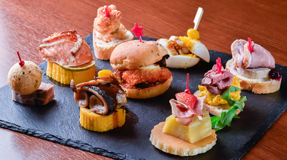 我們的餐廳晚餐營業時間為 17:00 至 21:00。 Pinchos 售價 300 日元，可外帶。新鮮出爐的披薩有三種口味：瑪​​格麗特披薩、起司披薩、培根玉米披薩。此外，精緻的烤牛肉博洛尼亞醬配上蛋黃也值得一嚐！ 16:00 至 19:30 期間還有歡樂時光，您可以以 1,100 日圓的價格享用兩杯飲料套餐。